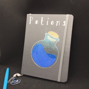 May include: Gray notebook with a blue potion bottle graphic and the word "Potions" in white lettering.