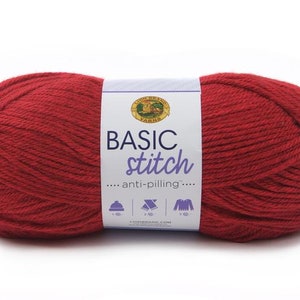 May include: A skein of Lion Brand Basic Stitch yarn in a deep red color. The label reads "Basic Stitch... anti-pilling..." and shows a hat, scarf, and sweater.