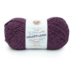 May include: A skein of Lion Brand Heartland yarn in the color "Heather" with a purple and grey marled effect. The label reads "Lion Brand Heartland Yarn - Hand-Crafts - Artisanat - Sensationally Soft - Sensation Douce - Premium Acrylic - Acyclique de Qualite Superieure".