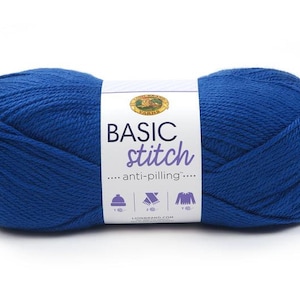 May include: A skein of blue yarn with a white label that reads "BASIC stitch anti-pilling". The label also features icons of a hat, scarf, and sweater. The yarn is a vibrant shade of blue.