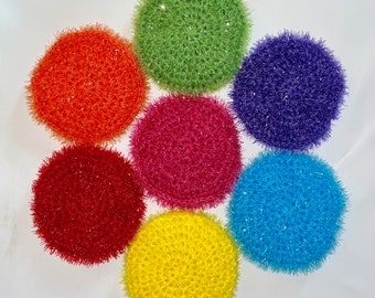 May include: Seven round crocheted scrubbers in a rainbow of colors: orange, red, pink, green, blue, purple, and yellow.