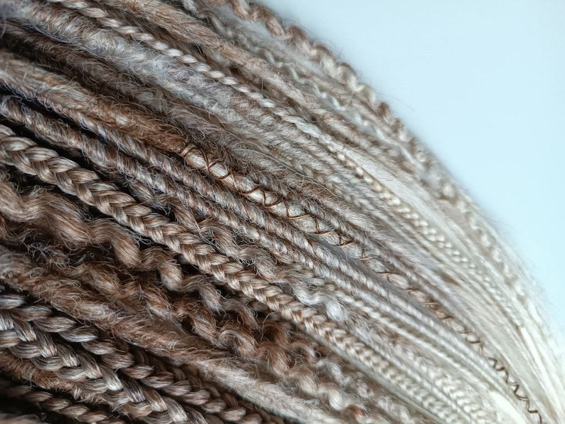May include: A bundle of brown and blonde synthetic dreadlocks. The dreadlocks are made of kanekalon hair and are ready to be installed.