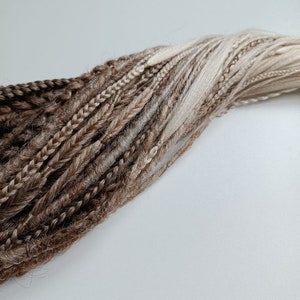 May include: A bundle of brown and blonde synthetic dreadlocks.