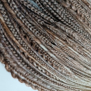 May include: A bundle of brown and blonde synthetic dreadlocks. The dreadlocks are made of kanekalon hair and are ready to be installed.