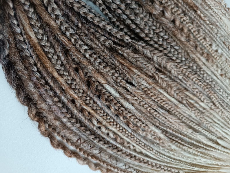 May include: A bundle of brown and blonde synthetic dreadlocks. The dreadlocks are made of kanekalon hair and are ready to be installed.