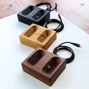 A collection of three wireless magnetic charging stands: walnut, oak, and black stained walnut, showcasing their distinct, handcrafted finishes for a stylish and functional desk setup.