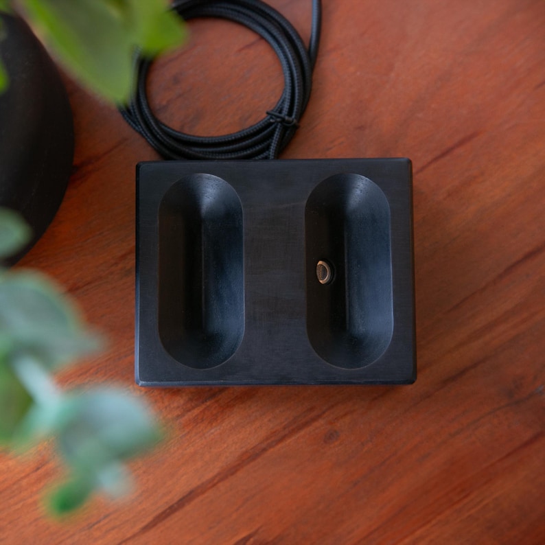 Black stained walnut wireless magnetic charging stand with AirPods Max, offering a modern, sleek design that blends seamlessly into any workspace for efficient and stylish charging
