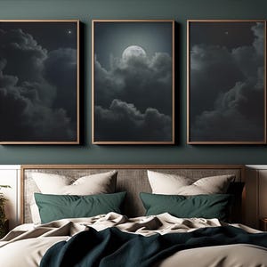 Könnte beinhalten: Drei gerahmte Kunstdrucke, die einen Nachthimmel mit Wolken und einem Vollmond zeigen. Das Kunstwerk wird über einem Bett mit Kissen und einer dunkelblauen Decke ausgestellt. Die Rahmen sind in einem warmen Braunton gehalten.