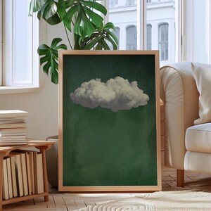 May include: A framed print of a single white cloud against a dark green background.