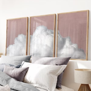 Puede incluir: Tres impresiones enmarcadas de una nube blanca sobre un fondo rosa pálido. Las impresiones están dispuestas en fila, con la nube de la impresión central siendo la más grande.