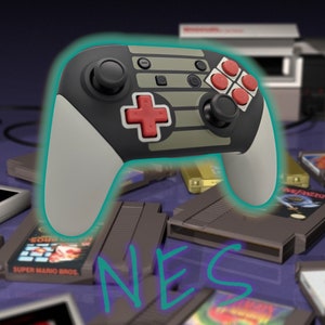 May include: A black and grey Nintendo Switch controller with red buttons and a grey and white NES design. The controller is surrounded by NES game cartridges.