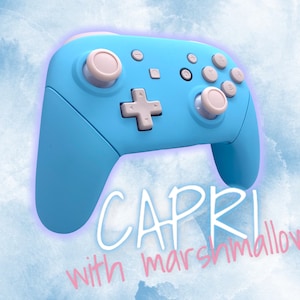 May include: A light blue Nintendo Switch controller with white buttons. The text "CAPRI with marshmallow" is written below the controller.