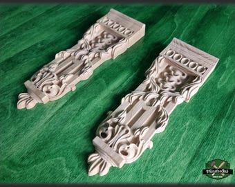 A pair of wooden brackets, a carved wooden shelf