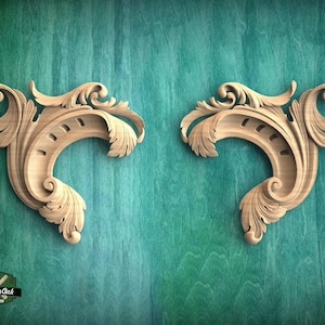 two ornate wooden carvings with intricate scrollwork and floral designs, set against a teal-colored background.