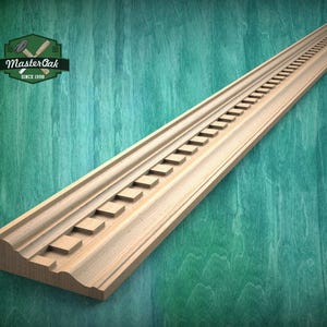 May include: A long, light-colored wooden molding with a decorative stepped design. The molding has a series of rectangular cutouts along its length and a curved edge. The logo "Master Oak Since 1998" is in the upper left corner.