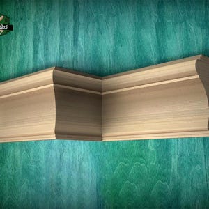 May include: A light-colored wooden crown molding piece featuring a decorative profile with a sharp 90-degree corner angle. The wood grain is visible on the smooth surface. The logo Master Oak Since 1990 is visible in the upper left corner.