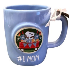 May include: A white ceramic mug with a black handle and the text "But First, Coffee" in a handwritten style. The mug is on a white surface. The mug is approximately 4 inches tall.