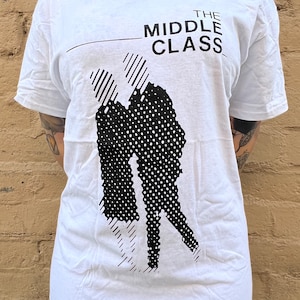 May include: White t-shirt with a black and white graphic design of two people dancing. The text "THE MIDDLE CLASS" is printed above the graphic.