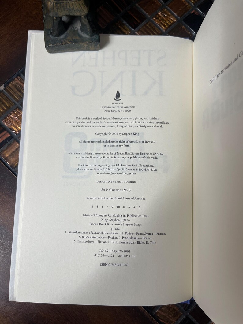 Może przedstawiać: Otwarta książka z tekstem z powieści Stephena Kinga, "From a Buick 8". Strona zawiera informacje o prawach autorskich, dane wydawcy i dane Biblioteki Kongresu. Książka jest otwarta na stronie z tekstem i dekoracyjnym ogranicznikiem do książek.