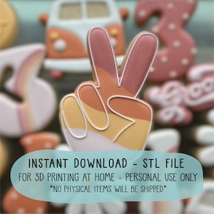 Può includere: Un download istantaneo di un file STL per la stampa 3D di uno stampino per biscotti a forma di segno della pace. Lo stampino per biscotti è progettato con un motivo a strisce multicolore in tonalità di rosa, arancio e giallo.