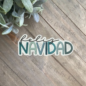 Puede incluir: Una pegatina con el texto "Feliz Navidad" en una fuente festiva y colorida. La pegatina está decorada con un esquema de color verde y azul.