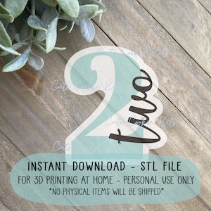 May include: A light blue 3D printed number two with the word "two" written in black cursive. The image includes the text "INSTANT DOWNLOAD - STL FILE FOR 3D PRINTING AT HOME - PERSONAL USE ONLY *NO PHYSICAL ITEMS WILL BE SHIPPED*"