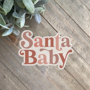 May include: A pink and red graphic design with the text "Santa Baby" on a wood background.