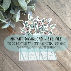 Puede incluir: Un archivo STL imprimible en 3D para un letrero de "Mama" con un jarrón de flores. El letrero es de color azul claro con un contorno blanco. El jarrón está lleno de flores rosas, blancas y azules. El texto "INSTANT DOWNLOAD - STL FILE FOR 3D PRINTING AT HOME - PERSONAL USE ONLY *NO PHYSICAL ITEMS WILL BE SHIPPED*" se muestra debajo del letrero.