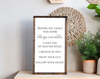 May include: A wooden sign with a white background and black text that reads "Before you leave this home always remember I love you no matter what. I believe in you. Trust your gut. Follow your heart."