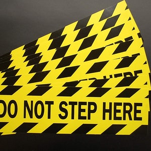 May include: A stack of yellow and black caution tape with the text "DO NOT STEP HERE" printed on the tape.
