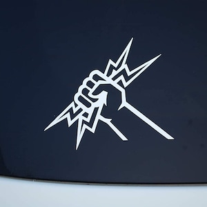 May include: A white vinyl sticker of a fist gripping a lightning bolt. The sticker is on a black surface.
