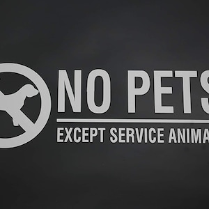Puede incluir: Un cartel en blanco y negro con un círculo rojo y una línea diagonal que lo atraviesa. Dentro del círculo hay una silueta de un perro. El cartel dice "NO PETS EXCEPT SERVICE ANIMALS".