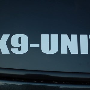 May include: White vinyl sticker with the text "K9-UNIT" on a black background.