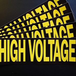 May include: A stack of black and yellow warning stickers with the text "HIGH VOLTAGE" printed in yellow letters.