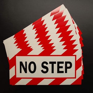 May include: A stack of red and white striped warning signs with the text "NO STEP" in black letters.