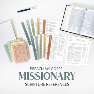 May include: A collection of study cards titled Preach My Gospel Missionary Scripture References, featuring muted pastel colors, alongside a lined notepad, a blue pen, and an open book with white pages and black text. The cards list various lessons.
