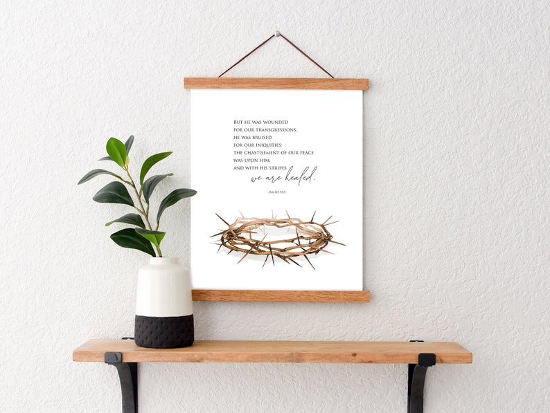 May include: A printable wall art design featuring a crown of thorns with the text "BUT HE WAS WOUNDED FOR OUR TRANSGRESSIONS, HE WAS BRUISED FOR OUR INIQUITIES: THE CHASTISEMENT OF OUR PEACE WAS UPON HIM, AND WITH HIS STRIPES WE ARE HEALED."