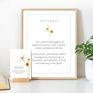 May include: A framed wall print and a smaller matching card featuring the text SEPTEMBER, I am a beloved daughter of heavenly parents, with a divine nature and eternal destiny. I lead, teach, and mentor others courageously by drawing on the power and authority of God and listening to the Spirit, decorated with small yellow and white flowers.