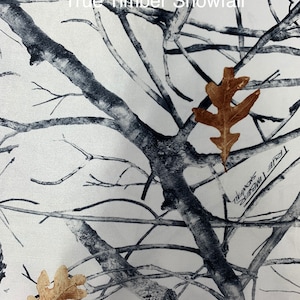 May include: A white and gray camouflage pattern with the text "True Timber Snowfall". The design features a network of tree branches and scattered brown leaves.