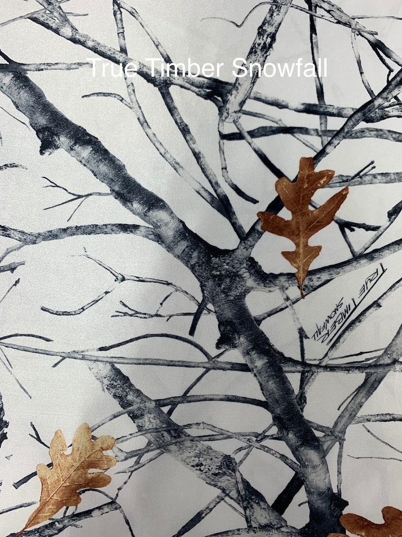 May include: A white and gray camouflage pattern with the text "True Timber Snowfall". The design features a network of tree branches and scattered brown leaves.