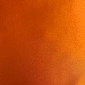 May include: A solid orange background with a subtle, textured surface. The color gradient shifts from a darker shade at the bottom to a lighter, warmer tone towards the top right corner. The overall effect is a smooth, uniform appearance.