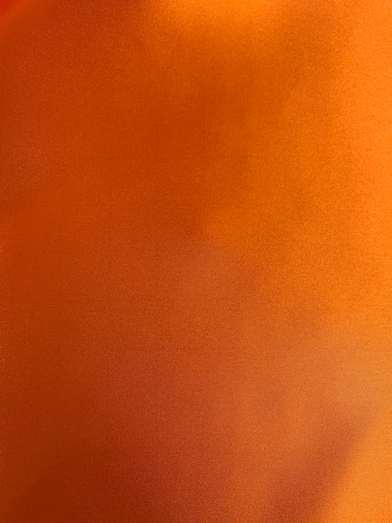 May include: A solid orange background with a subtle, textured surface. The color gradient shifts from a darker shade at the bottom to a lighter, warmer tone towards the top right corner. The overall effect is a smooth, uniform appearance.