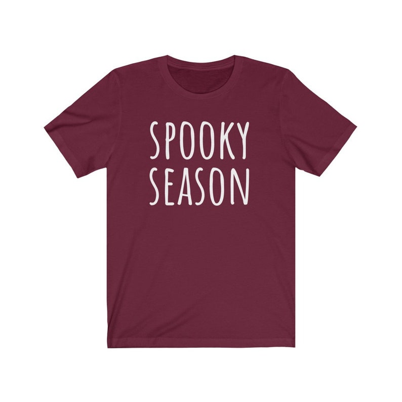 May include: Burgundy short-sleeved t-shirt with the text "SPOOKY SEASON" in white.