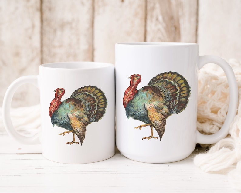 Puede incluir: Dos tazas de cer&aacute;mica blanca con una ilustraci&oacute;n colorida de un pavo en cada una. El pavo tiene la cabeza roja, plumas verdes y marrones y un pico amarillo.