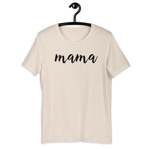 Może przedstawiać: Beżowa koszulka z napisem "mama" napisanym czarnym, ozdobnym pismem.