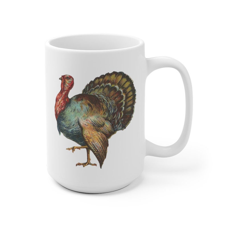 Puede incluir: Taza de cer&aacute;mica blanca con una ilustraci&oacute;n colorida de un pavo con la cabeza roja y el cuerpo marr&oacute;n, verde y azul.