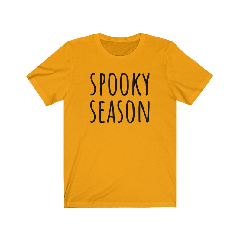 May include: A yellow short-sleeved t-shirt with the text "SPOOKY SEASON" printed in black.