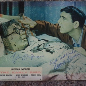 Handtekeningen van NORMAN WISDOM (1915 – 2010) en Edward Chapman (1901 – 1977), met de hand ondertekend op een UK Lobby Card (1965) 'The Early Bird'