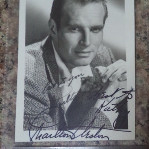 CHARLTON HESTON (1923 – 2008) Autógrafo en tarjeta fotográfica pequeña