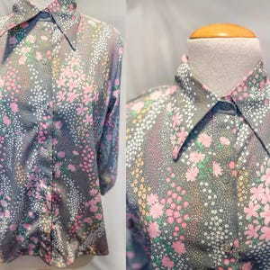 May include: A grey long-sleeved shirt with a large collar and a floral print in shades of pink and white.